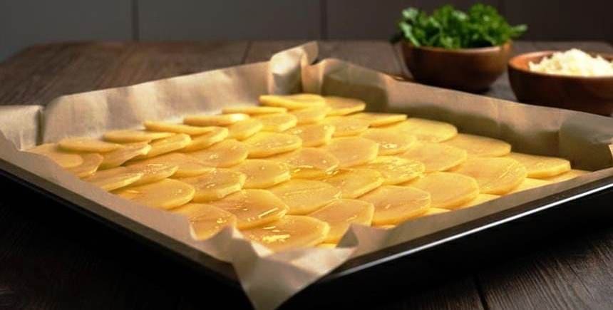 طريقة رص شرائح البطاطس الرفيعة في صينية الفرن لتحضير رول البطاطس